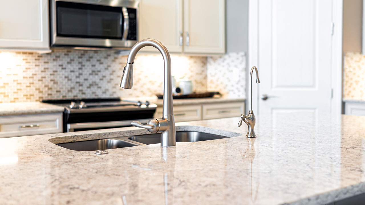 Clean kitchen counter with a sink faucet and a drinking water filter faucet