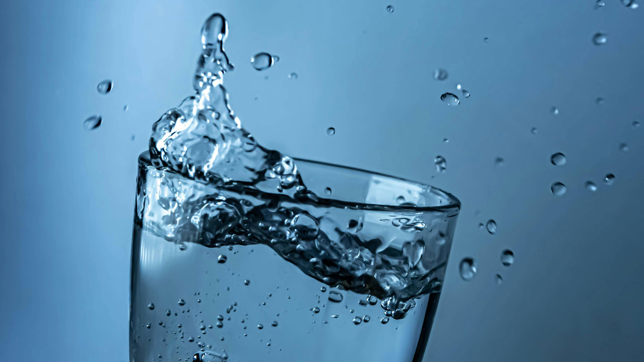 Clear water splashing out of a glass