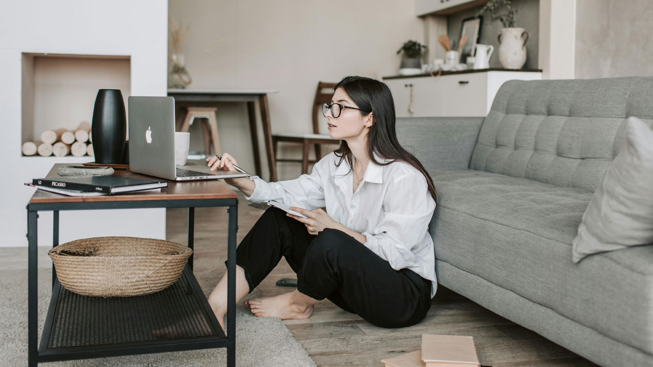 Woman on floor using laptop connected smart home