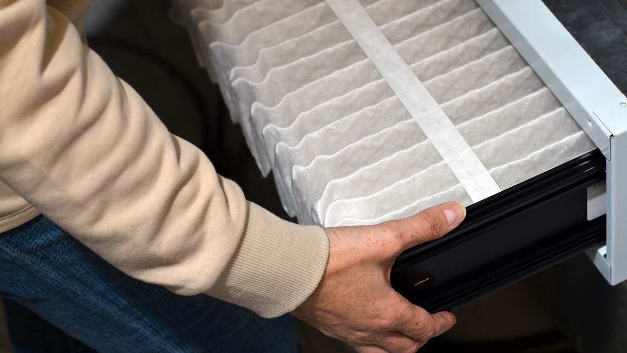Installing a new whole-house filter the deep pleated media visible in the filter cabinet