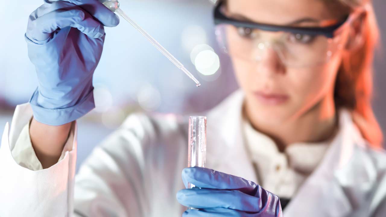 A professional lab technician carefully analyzes a water sample