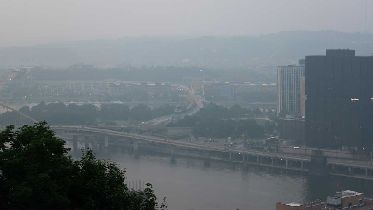 Hazy white wildfire smoke settled over a city