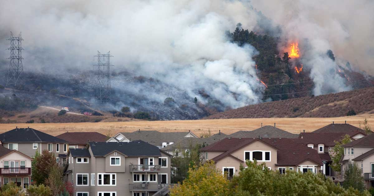 Wildfire smoke and visible flames in mountains releasing particulate matter and poor outdoor air quality