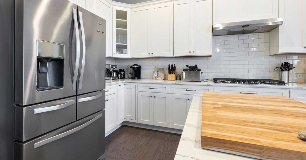 Premium Whirlpool refrigerator in a home kitchen with a water dispenser and ice maker water filter replacement