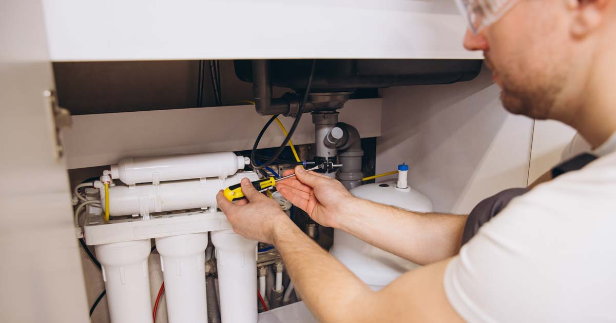 Water dealer technician installs an under sink reverse osmosis system for a customer